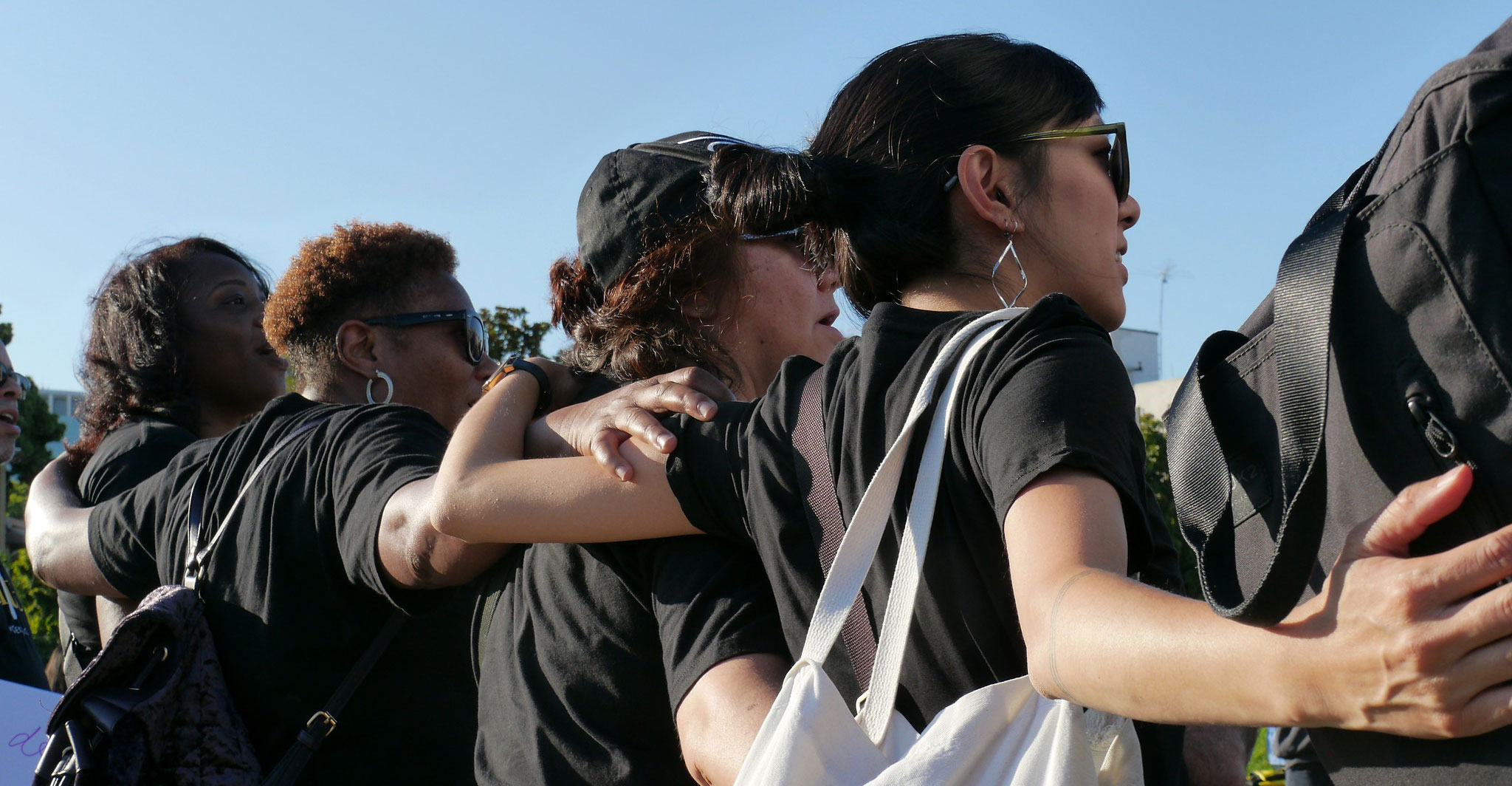 Women link arms in solidarity at a rally