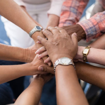 Hands overlap in a symbol of collaboration and support