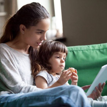 Mother and child reading together on a sofa