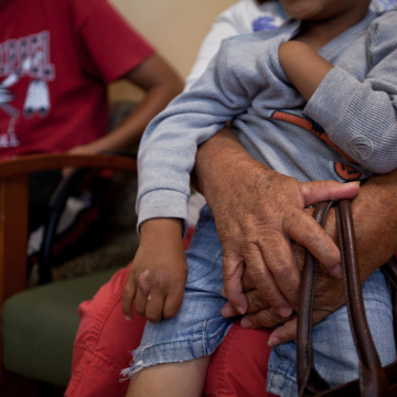 Elderly person holds grandson