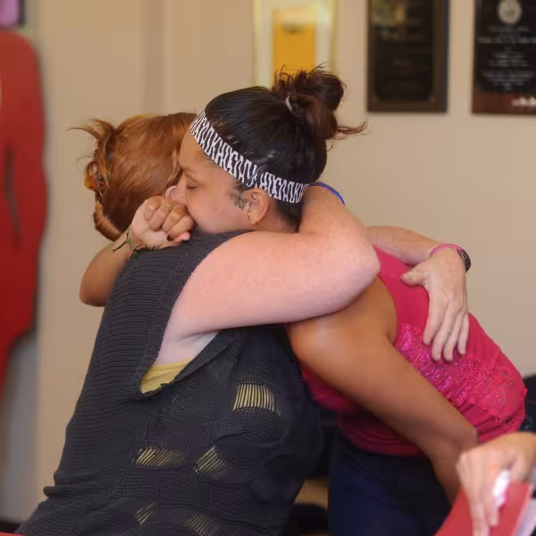 Two survivors of domestic violence hug